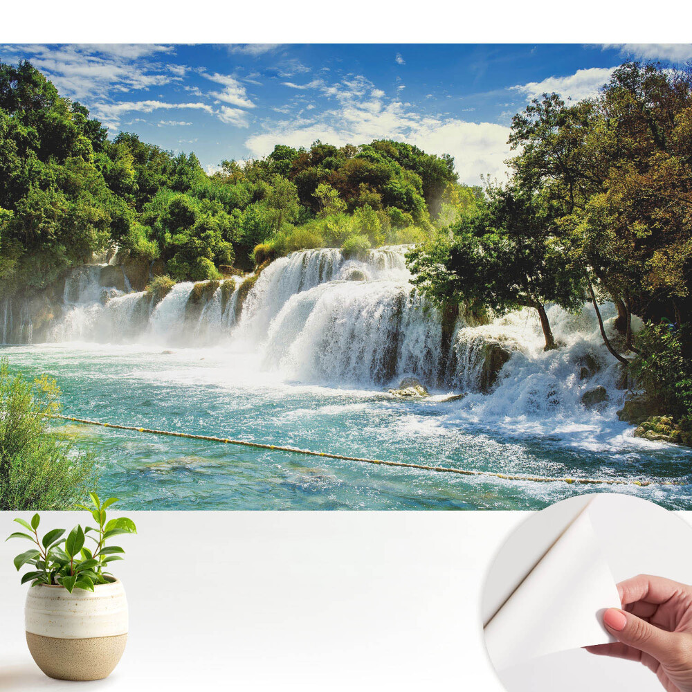 Tapéta Vízesés a napsütéses zöld tájban