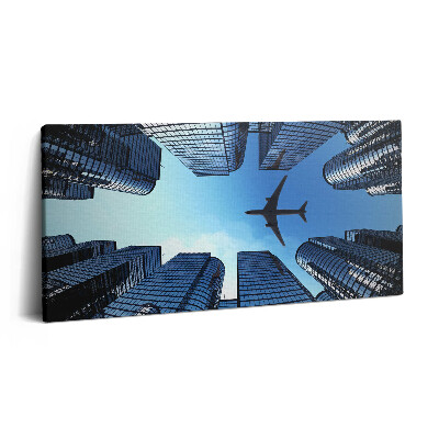 Vászonkép nyomtatás 120x60 Repülőgép az épületek felett