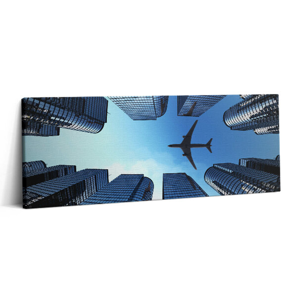 Canvas kép 125x50 Repülőgép az épületek felett