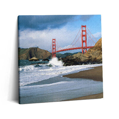 Vászonkép 60x60 Hullámok a tengerparton és egy piros híd