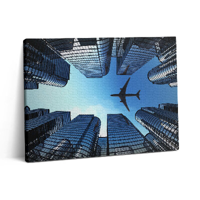 Vászonkép falra 80x60 Repülőgép az épületek felett