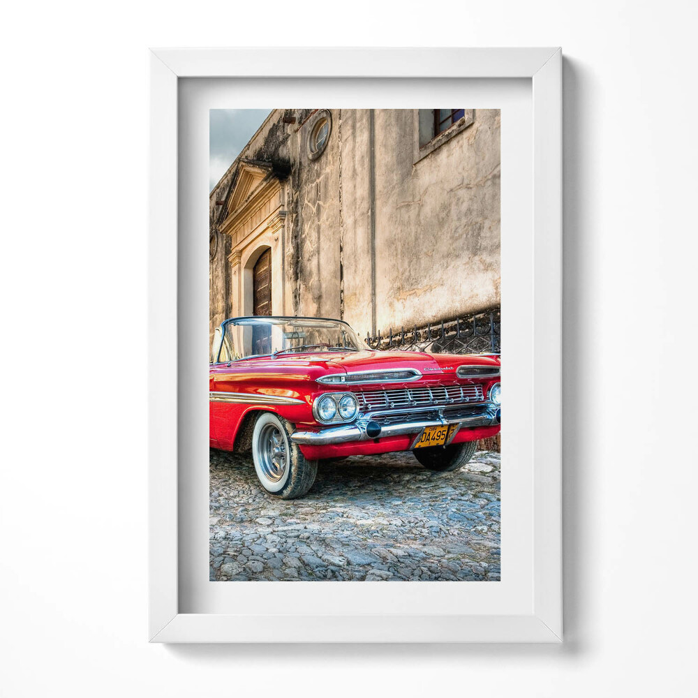 Keretezett kép Piros klasszikus autó egy régi épület előtt